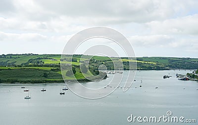 Sailboats at anchor off green Irish coast Stock Photo