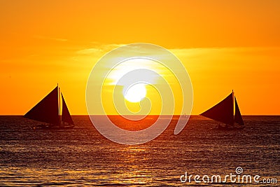 Sailboats at sunset on a tropical sea. Silhouette photo. Stock Photo
