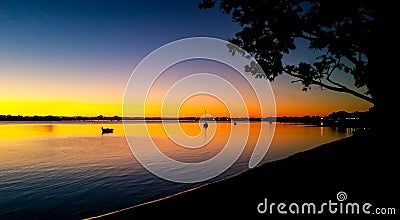 Sailboats in the sunset - view toward Bribie Island Bridge over the Pumicestone Passage with Glasshouse mountains on horizon Stock Photo