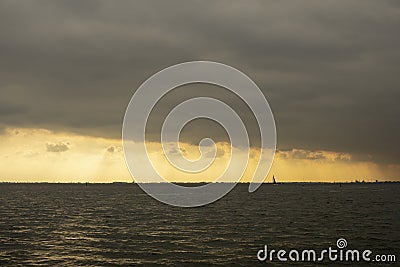 Sailing boat silhouette in front of the skyline of Amsterdam Stock Photo