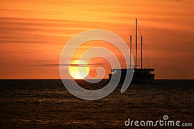 Sailing boat silhouetted at sunset Stock Photo