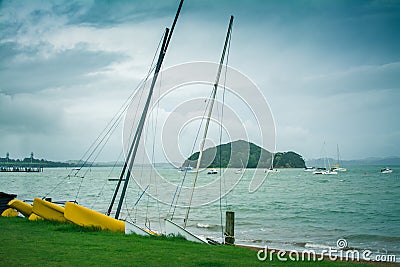 Sailing boats, catamarans, and kayaks at an empty beach by the sea. Stormy day Stock Photo