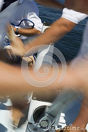 Sailors operating windlass on yacht Stock Photo