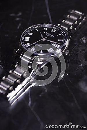 Saint-Imier, Switzerland 31.03.2020 - Closeup image of Longines watch lying on a marble table stainless steel case black Editorial Stock Photo