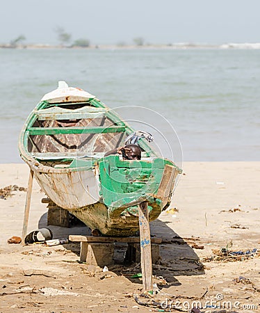 Saint-Louis, Senegal - October 20, 2013: Unidentified young African boy hiding in wooden boat and waving Editorial Stock Photo