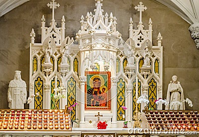 Saint Patrick`s Cathedral White Altar With Candles and Picture of Holly Mary Holding Jesus Christ. Interior Church Decoration in Editorial Stock Photo