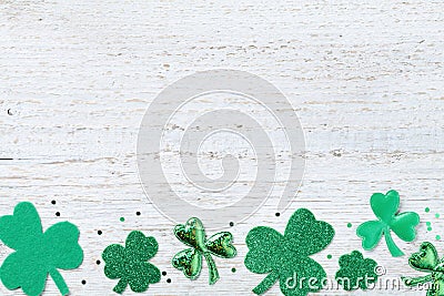 Saint Patricks Day border with green shamrock on white rustic board from above. Stock Photo