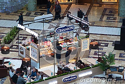 Saint Petersburg, Russia - February 16, 2019: Cinnabon`s diner at the Mall. Logo on the kiosk and visitors at the tables Editorial Stock Photo