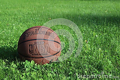 Saint Petersburg, Russia - JUNE 05 2019: basketball ball on green grass. concept of NBA playoff final. spalding basketball backgro Editorial Stock Photo