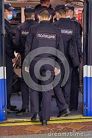 A group of policemen gets into an underground subway car Editorial Stock Photo