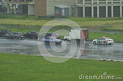 One car drives on a wet road past traffic cars during the rain Editorial Stock Photo