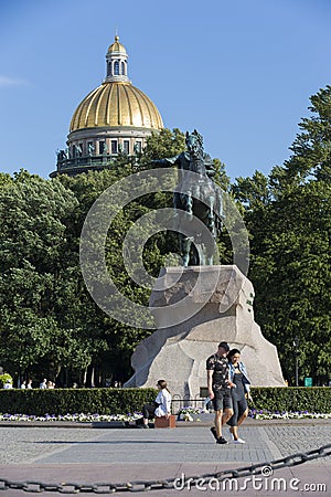 People on Senate Square by the Bronze Horseman equestrian statue of Peter the Great. St. Isaac`s Cathedral golden cupola dome Editorial Stock Photo