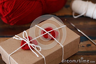 Saint Valentine decoration: handmade crochet red heart on gift p Stock Photo