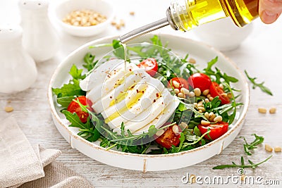 Salad with arugula, mozzarella cheese and pine nuts. Breakfast. Ketogenic, keto or paleo diet. Healthy food. Stock Photo