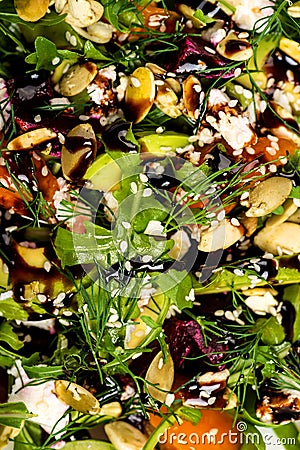 Salad with beetroot, avocado, feta cheese, rucola, tomato, various greens, pumpkin seeds in a white bowl. Diet healthy Stock Photo