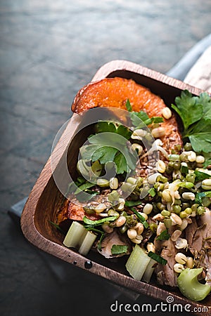 Salad with chicken, pumpkin, beans in a wooden bowl Stock Photo