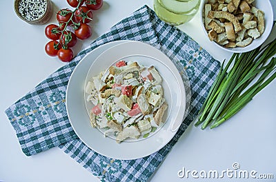 Salad with crackers, crab sticks, chicken fillet, fresh herbs and hard cheese seasoned with mayonnaise butter served in a white Stock Photo