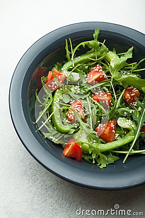 Salad of fresh vegetables and herbs in a plate on a white background, top view Stock Photo