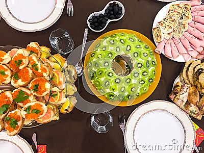 Salad with kiwi, ham, pieces of stuffed turkey, rolls with salmon at a Christmas dinner Stock Photo