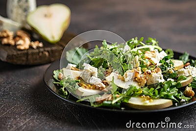 Salad of pear, blue cheese, arugula and nuts with spicy dressing Stock Photo