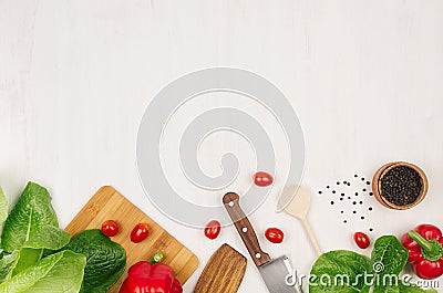 Salad, spinach, dill, parsley sheaves on white wood plank, top view, decorative border. Stock Photo