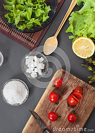 Salad of vegetables with spices. On a wooden surface. Pieces of vegetables, cherry tomatoes, spices, basil Stock Photo