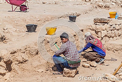 SALALAH, OMAN - FEBRUARY 25, 2017: Workers and archeologists at Sumhuram Archaeological Park with ruins of ancient town Khor Rori Editorial Stock Photo