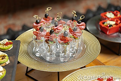 Salami canapes, bamboo skewers decorated with olive. Stock Photo