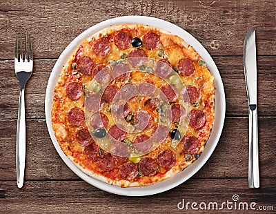 Salami pizza top view on plate with fork and knife Stock Photo