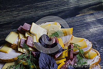 Salami, sliced ham and cheese salad and vegetables. Squeezing sausage and cured meat on a festive table Stock Photo