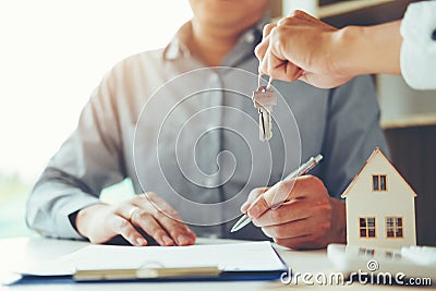 Sale agent giving Key house to customer and sign agreement contract, Insurance Home concept Stock Photo