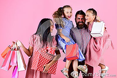 Sale, consumerism and people concept. parents and their daughters are holding paper bags. shopper team of relatives Stock Photo