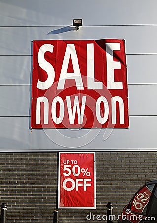 Sale now on - large red poster advertising a sale with 50% reductions. Stock Photo