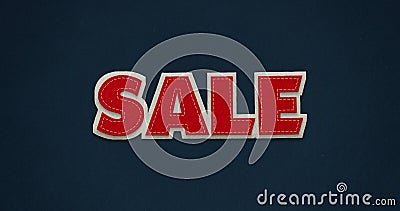 Sale. Red word with white contour on dark blue background with textile texture. Stock Photo