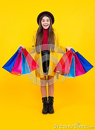 Sale and shopping concept. Teen girl holding shopping bags, isolated on studio background. Winter shopping sale. Excited Stock Photo