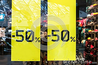 Sale sign on cloth store. Sticker - up to half-price 50 percent window with clothes during winter season Stock Photo