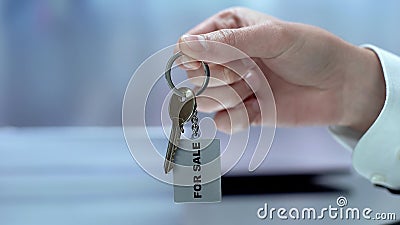 For sale written on keychain businessman demonstrating, real estate, purchase Stock Photo