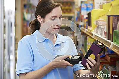 Sales Assistant Checking Stock Levels In Supmarket Using Hand He Stock Photo