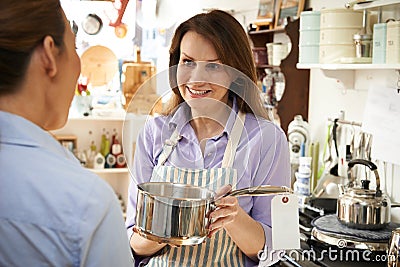 Sales Assistant In Homeware Shop Showing Customer Pan Stock Photo