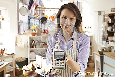 Sales Assistant In Homeware Store With Credit Card Machine Stock Photo