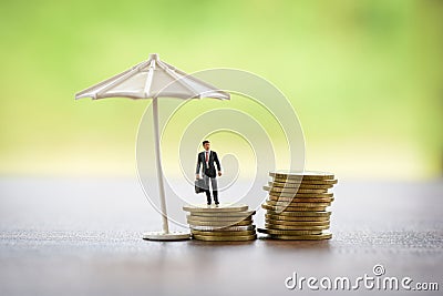 Sales insurance agreement concept / Businessman holding briefcase and umbrella protecting coin Stock Photo