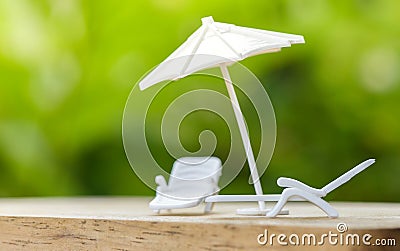 Sales insurance concept or plan relax on holiday umbrella protecting on bench chair for family Stock Photo