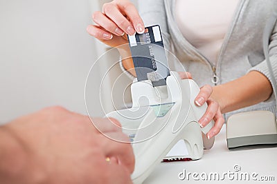 Sales person inserting card into scanner Stock Photo