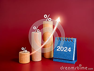 Rise up arrow and percentage icons on growth step graph wood sticks and 2024 year number on blue desk calendar on red. Stock Photo