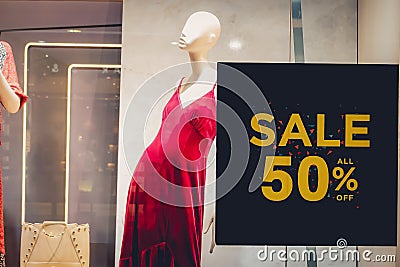 Sales promotion of women fashion clothes retail store in shopping mall, sale label sign sticker in front of shop door glasses Stock Photo
