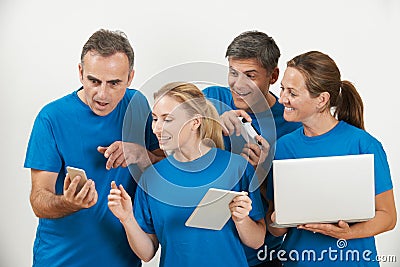 Sales Team Wearing Uniform With Selection Of Techno Gadgets Stock Photo