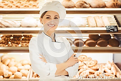 Sales woman in bakery shop standing in front of delicious bread Stock Photo
