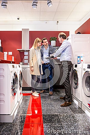 Salesman Explaining Product Quality At Appliances Store Stock Photo