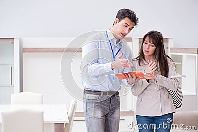 The salesman explaining to woman customer at furniture store Stock Photo