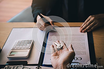 Salesman house brokers provide key to new homeowners in office Stock Photo